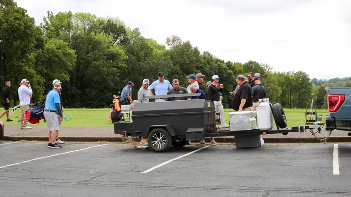 Participants visiting the barbecue trailer outside the clubhouse.