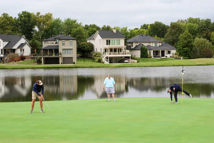 Participants taking turns putting beside the lake.