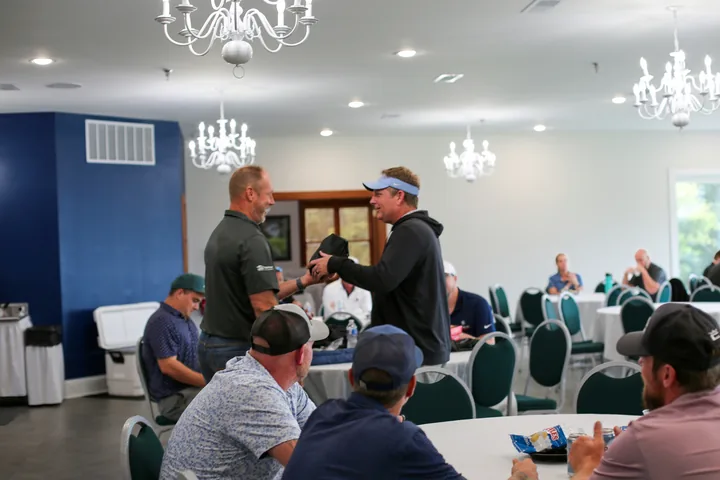 Participants greeting each other during the gathering in the clubhouse dining room.